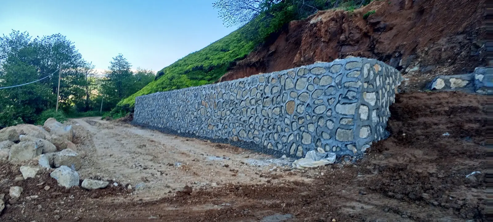 Toprak yol boyunca uzanan taş duvar